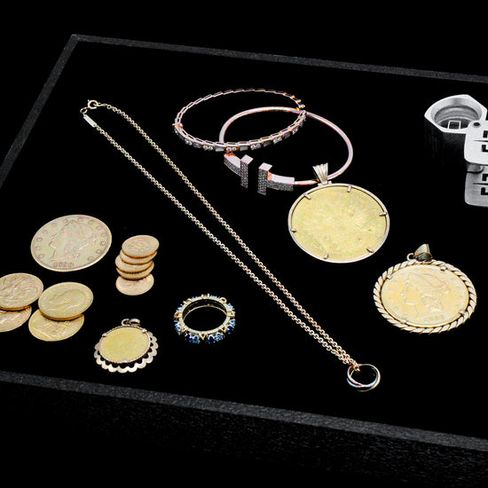 Photo of gold coins and jewelry on black background