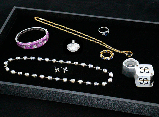 Photo showing various jewelry in black box.